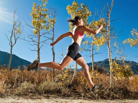 A women running through the yellow Aspen tree in the mountains.