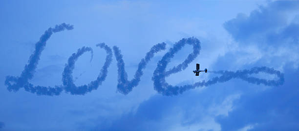 love in the sky airplane makes a love word in the cloudy sky words in the sky stock pictures, royalty-free photos & images