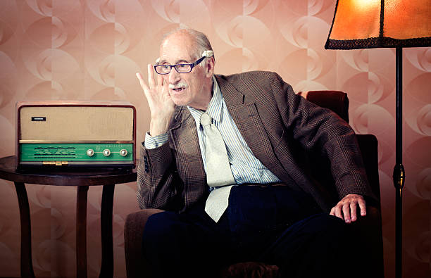 senior man leaning in to listen to retro radio - foton med överkroppsbild bildbanksfoton och bilder