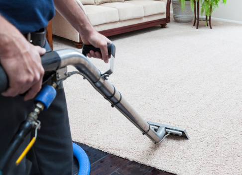 Man cleaning carpets in home