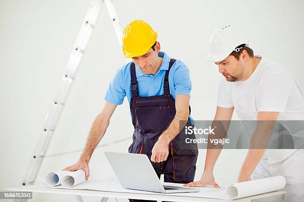 Manual Workers At Construction Site Stock Photo - Download Image Now - House Painter, Computer, Construction Industry