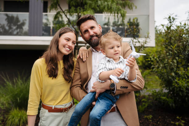 istock Smiling parents with little son blowing on wind turbine model. 1686153904