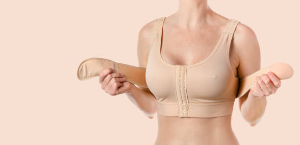 istock Woman wearing a compressing bra with a stipe after breast augmentation surgery. 1686165572