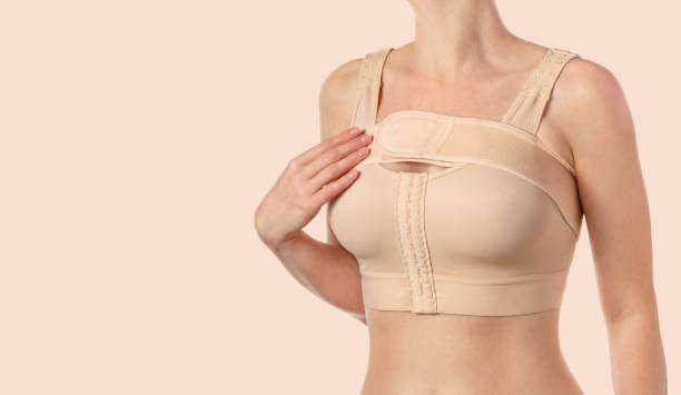 istock Woman wearing a compressing bra with a stipe after breast augmentation surgery. 1686165575
