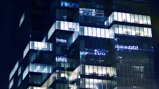 istock Pattern of office buildings windows illuminated at night. 1686168260