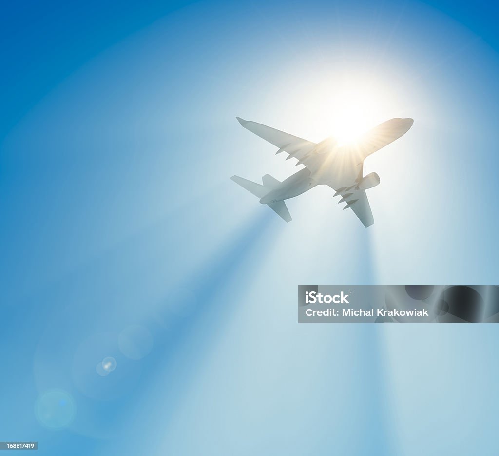 Passenger airplane flying against the sun Passanger airplane flying against the sun. Airplane Stock Photo