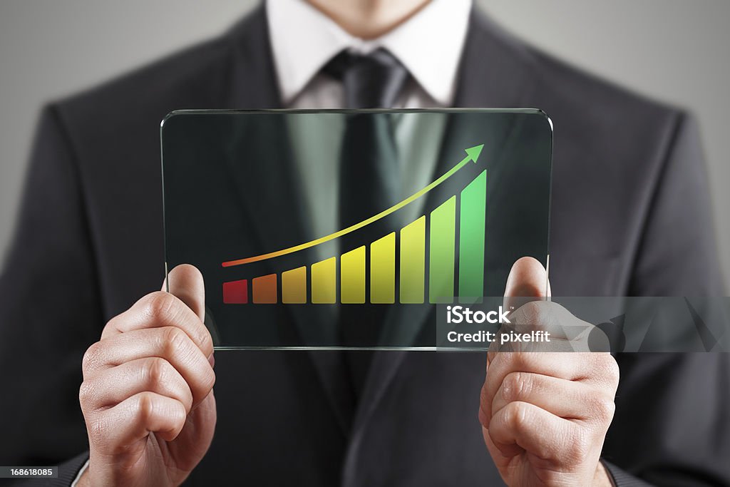 Success chart Businessman holding futuristic digital tablet with rising chart Chart Stock Photo