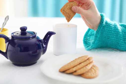 dipping biscuit into tea