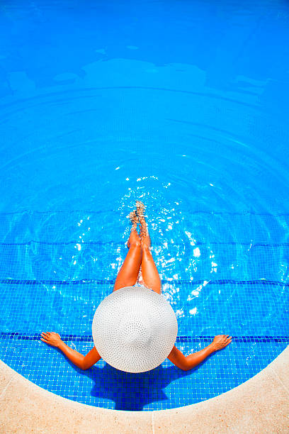 istock woman relaxing in a resort swimming pool 168619701