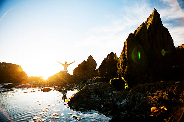 Female meditating on the rocks