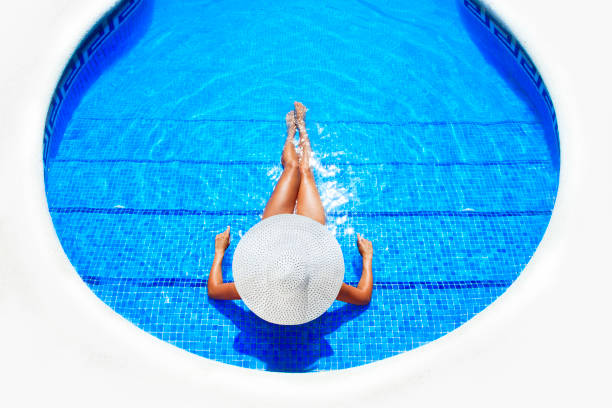 istock woman relaxing in a resort swimming pool 168620157