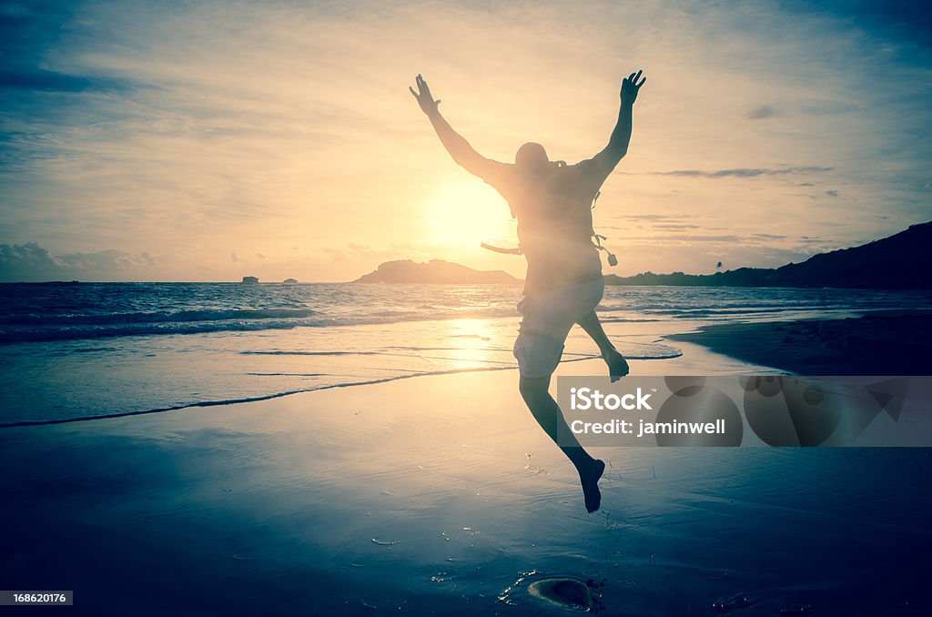 Homme sauter sur la plage sur matin, Rayon de soleil - Photo de Cool libre de droits