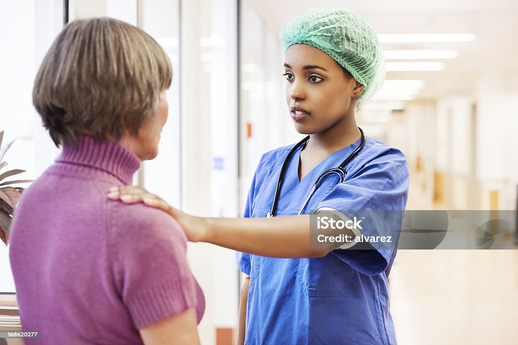Enfermera reconfortante de un paciente en el hospital. - Foto de stock de Enfermera libre de derechos