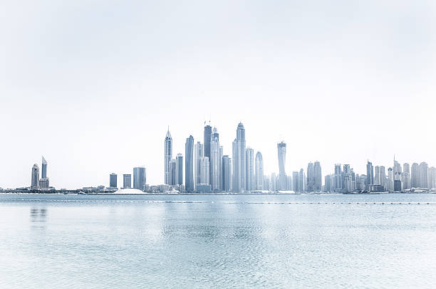 Skyline of a city of skyscrapers Skyscrapers on the coast and ocean with a bleached effect dubai skyline stock pictures, royalty-free photos & images