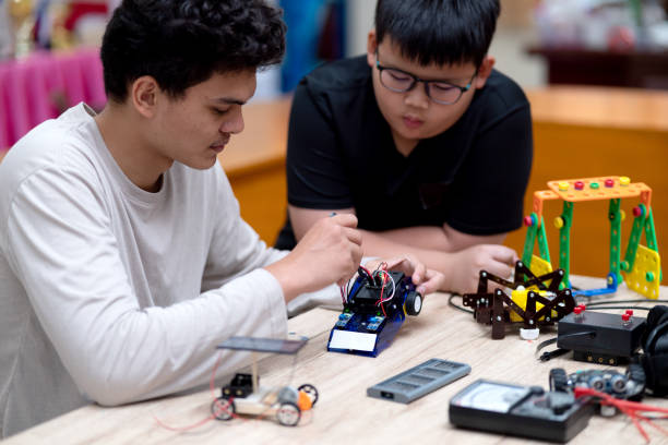 istock young man and a boy studying electronic assembly as an experiment for robotic 1686208940