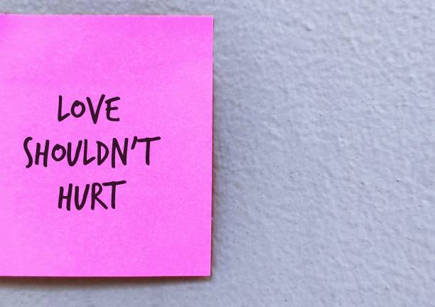 istock Pink note stick on grey background with handwritten LOVE SHOULD NOT HURT, means everyone deserves to be safe in relationship, should not be hurt by partner  physically, emotionally, or sexually 1686214832