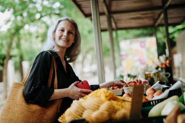 ritratto di una bella donna matura che fa shopping al mercato della città. - mature women beautiful senior women menopause foto e immagini stock