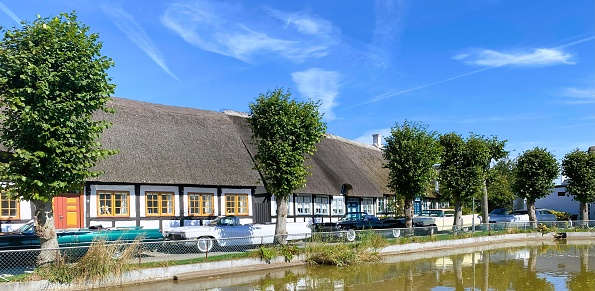 Cadillacs encircle the village pond in the historic town of Nordby on Samsø Island, creating a charming scene. The photograph was captured on September 11th, 2023, on the scenic Samsø Island in Denmark.