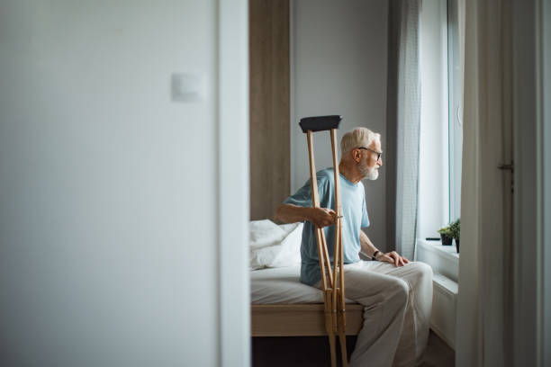 istock Senior man with crutches spending time alone in his apartment. 1686230777
