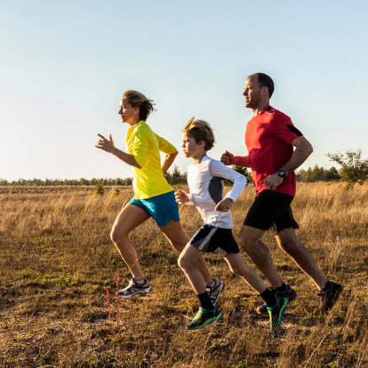 A family jogging in a field.
