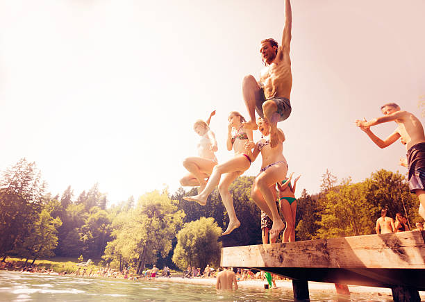 istock friends jumping into the water 168623974