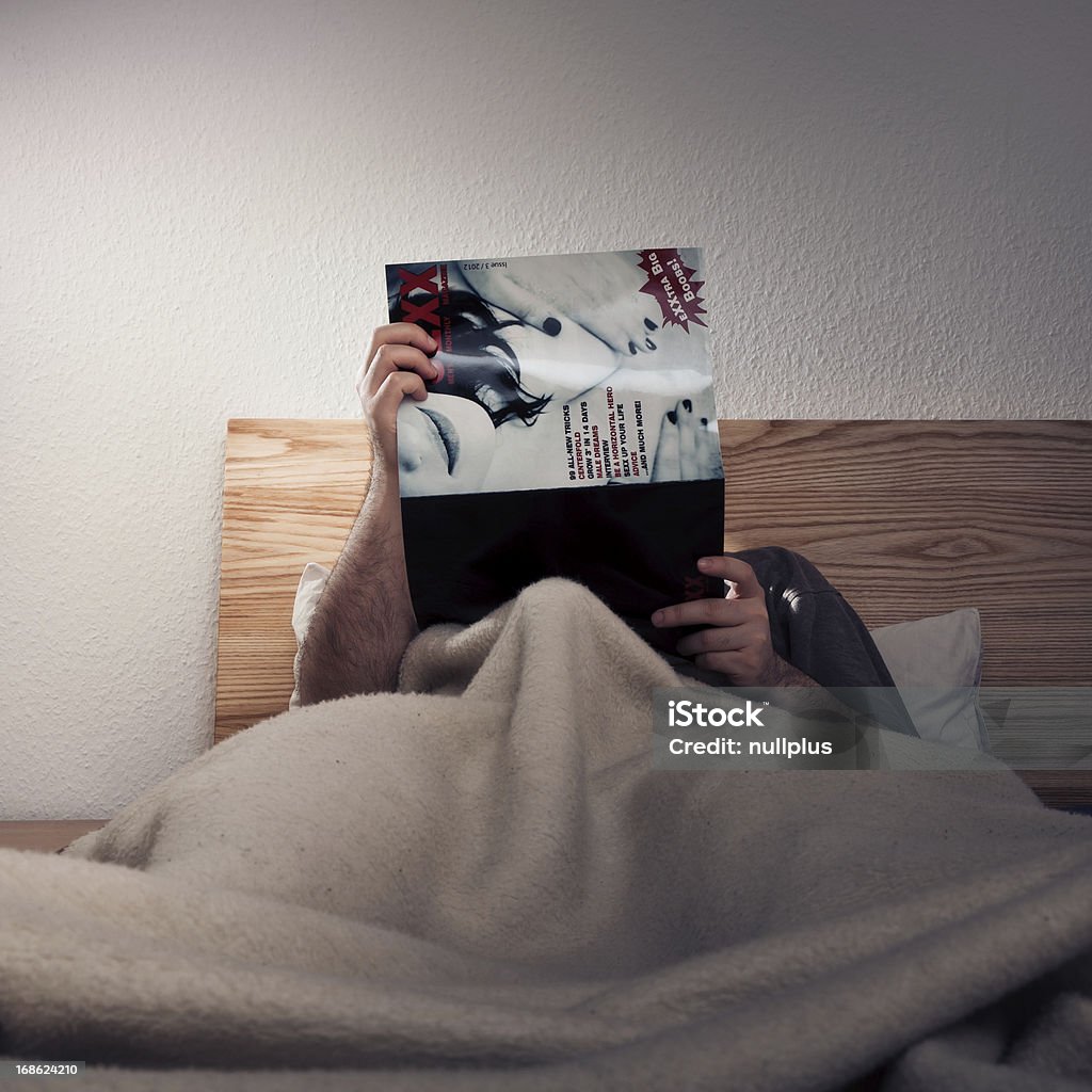 man enjoying a porn magazine Pornography Stock Photo