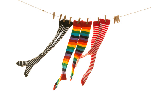 three pair of coloured socks and hanging on the clothesline blowed with wind. Image isolated on white background