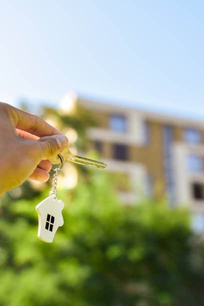 istock Hand holding key with house pendant. 1686255156