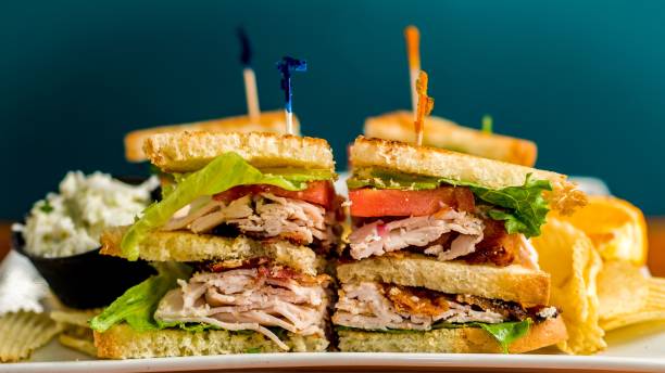 istock Freshly cut sandwich on a plate, accompanied by a side of chips. 1686264082