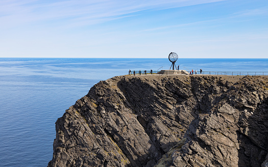 Travellers visiting the globe landmark at the North Cape (Nordkapp) in Norway