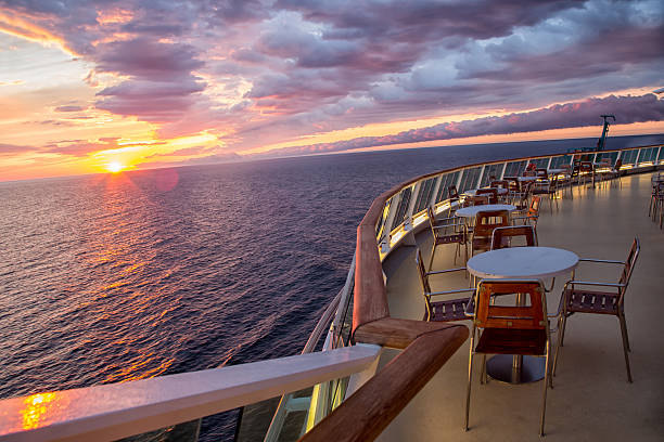 Sunset on a Cruise Ship Sunset on a cruise ship with tables and chairs.  Carefully shot scene making sure that no copyrighted ship design is depicted.Sunset on a cruise ship with tables and chairs.  Carefully shot scene making sure that no copyrighted ship design is depicted. boat deck stock pictures, royalty-free photos & images