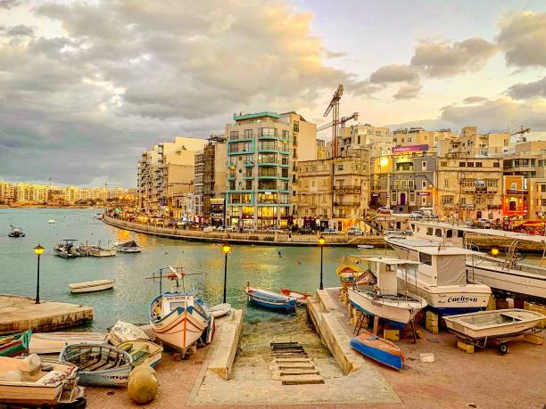 Twilight view of Spinola Bay, Malta. St. Julian’s, Malta - March 12, 2023:  An evening view across Spinola Bay on the Mediterranean island of Malta. st julians bay stock pictures, royalty-free photos & images