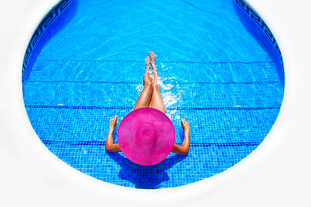 istock woman relaxing in a resort swimming pool 168629003