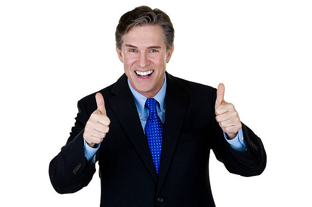 Excited businessman gesturing thumbs up Horizontal composition of a mature businessman gesturing thumbs up and smiling  cheesy grin photos stock pictures, royalty-free photos & images
