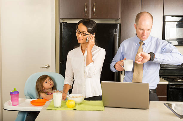 Starting the day Businessman and woman getting ready for work with their toddler in the morning urgency mother working father stock pictures, royalty-free photos & images