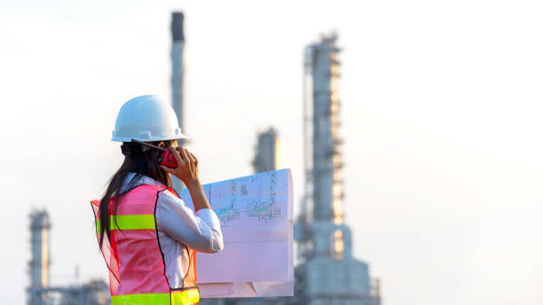 istock Engineers woman holding blueprint and report schedule for workers security control at power plant energy industry. Engineer and industry Concept 1686300374