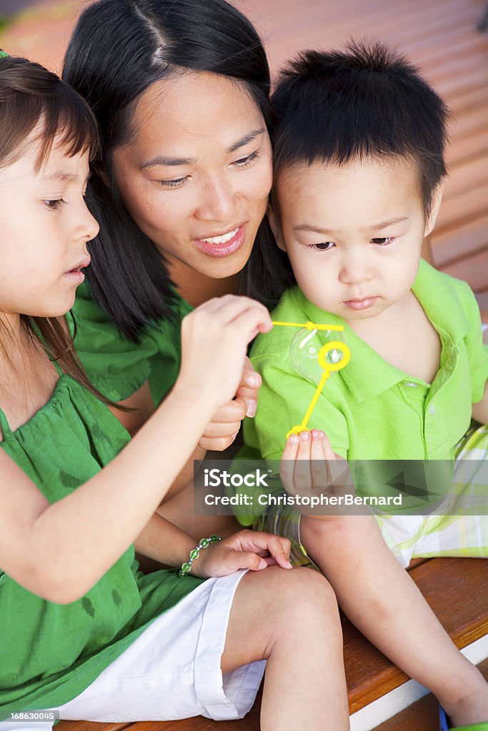 Famiglia giocando con le bolle - Foto stock royalty-free di 2-3 anni