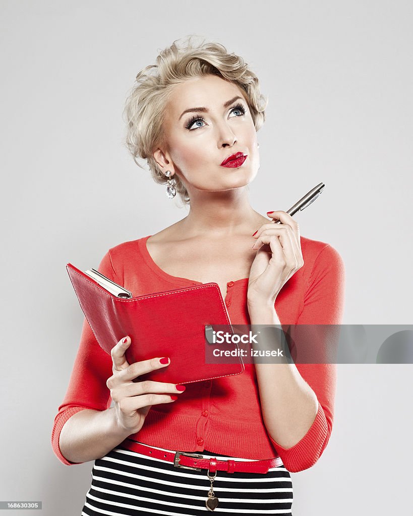 Elegant woman with calendar Portrait of penisive woman holding a calendar and pen in her hands, looking up. Women Stock Photo