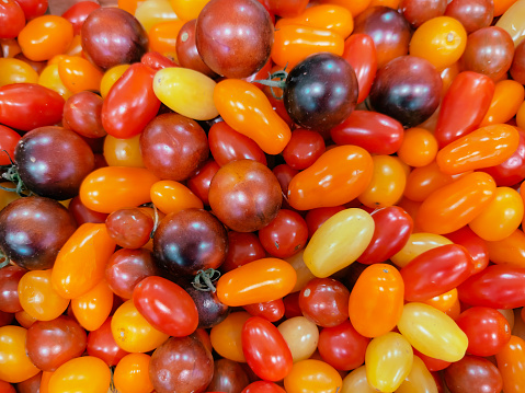 Different sorts of tomatoes as background, top view