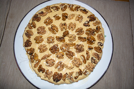 Round cake with cream and Greek nuts on a round tray. Tasty cake