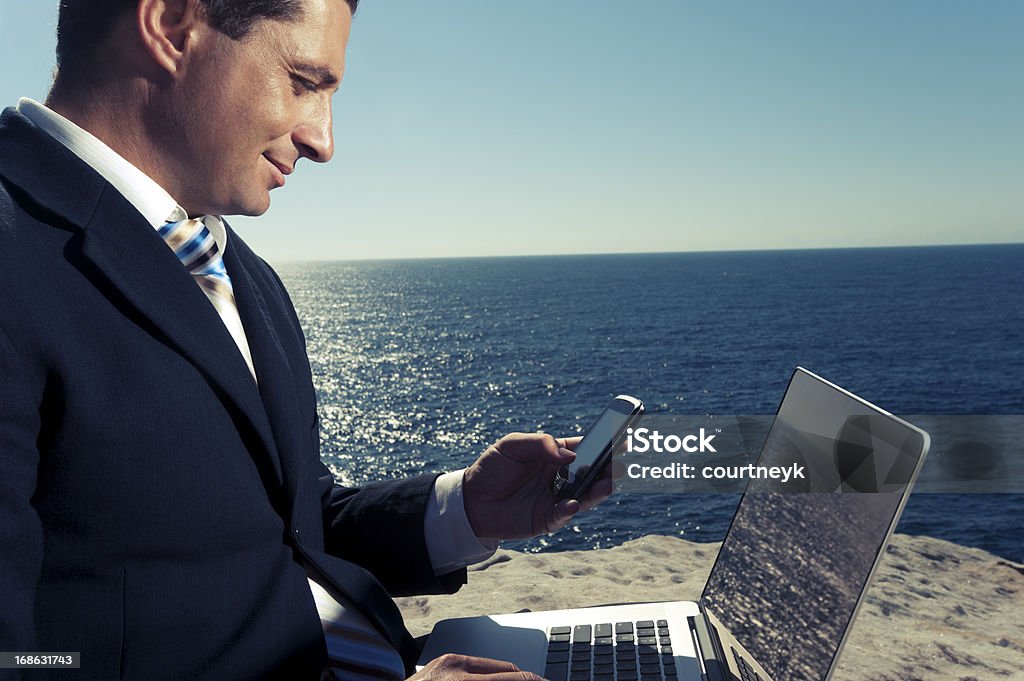 Uomo d'affari rilassante lavorando sul portatile all'aperto. - Foto stock royalty-free di Affari