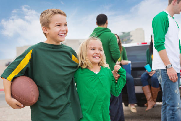 Excited kids watching football game at tailgate party Excited kids watching football game at tailgate party people family tailgate party outdoors stock pictures, royalty-free photos & images