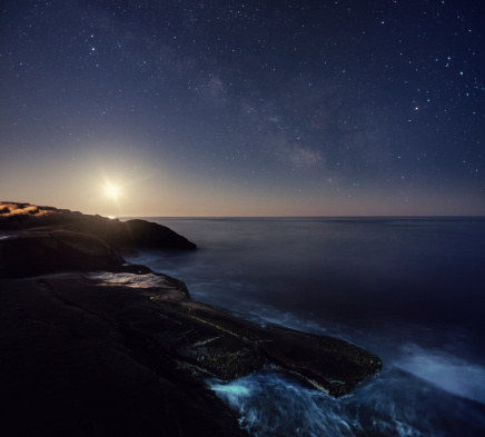 The rising Last Quarter Moon shines brightly over the Atlantic along with the Milky Way.  Long exposure shot at high ISO.