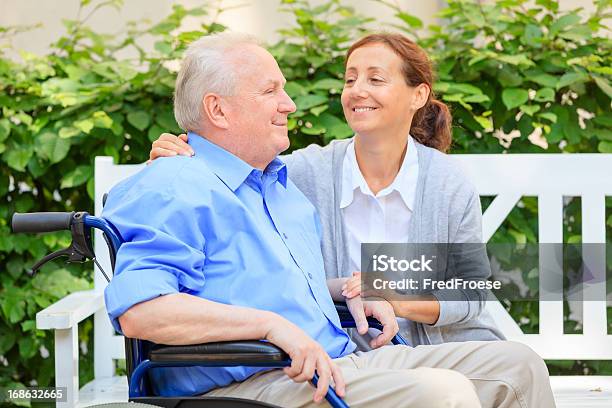 Idoso Sentado Em Uma Cadeira De Rodas Com O Prestador De Cuidados De Saúde - Fotografias de stock e mais imagens de 70 anos