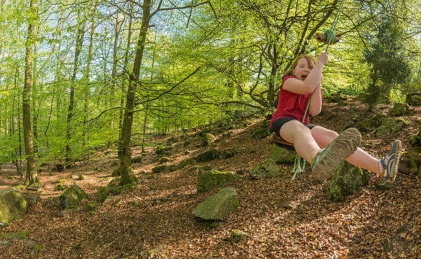 istock Child having fun on rope swing in summer forest 168632727