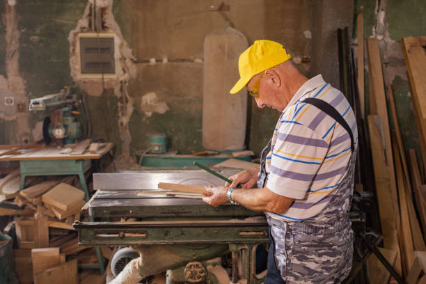 istock Carpenter measuring piece of wood in workshop 1686334224