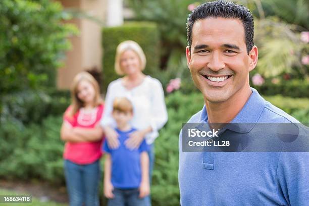 Foto de Pai Feliz Com Sua Família No Fundo e mais fotos de stock de 30 Anos - 30 Anos, Adulto, Adulto de idade mediana