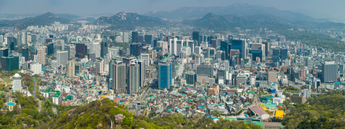 Aerial panoramic vista across the skyscrapers and landmarks, mountain parks and crowded suburbs of central Seoul, South Korea. ProPhoto RGB profile for maximum color fidelity and gamut.
