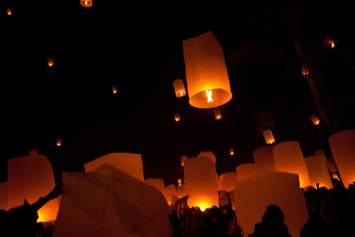 Locals and tourists alike lighting there lanterns before they make a wish and send them off into the night sky at the Loi Krathong festival in Chiang Mai, Thailand.