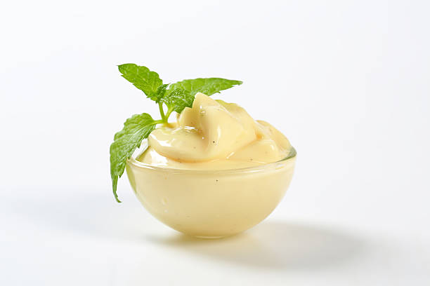 Vanilla cream in a bowl garnished by mint leaf smooth vanilla cream with fresh mint leaves in a glass bowl custard stock pictures, royalty-free photos & images